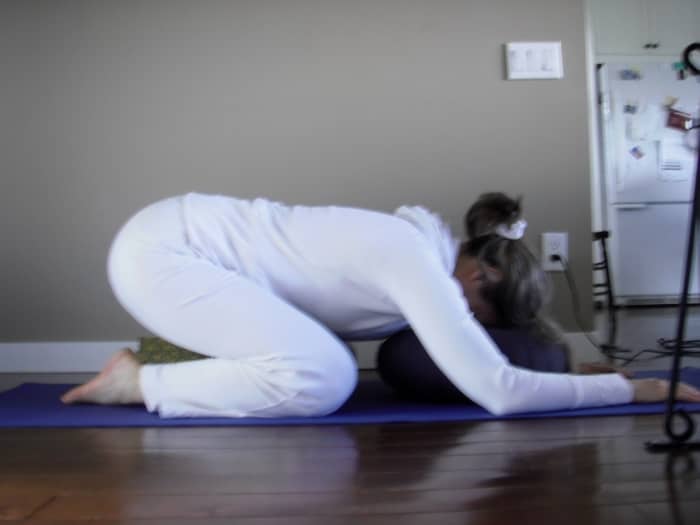 If you are more comfortable with support, use a bolster or cushion under your chest and forehead, and a rolled blanket or yoga block between your calves and thighs.