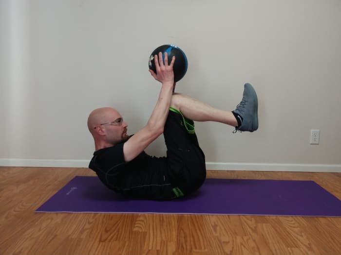 Once your knees have touched the ball, extend back to starting position and repeat, keeping your feet and hands about 6 inches off the floor.