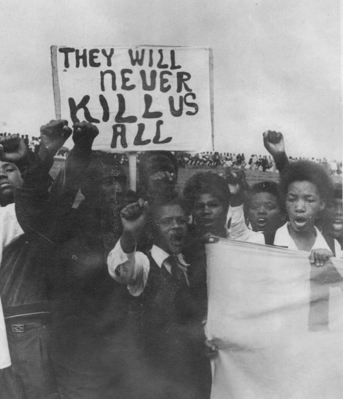 The Poster from the youth says it all. 100,000 Attended this funeral at Kwanobuhle Stadium, in Uitenhage. to show their anger and resolve