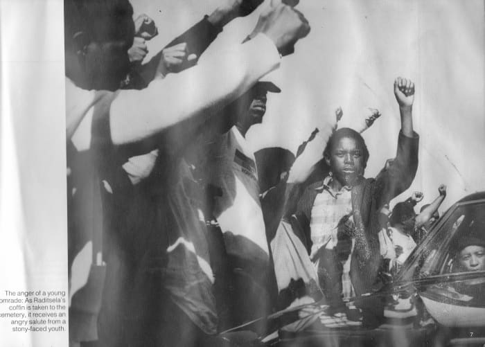 Stony faced youth show their anger and resolve at Mr. Raditsela's funeral, a union shop stewart who was killed in detention