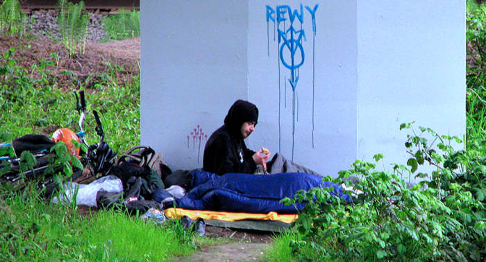 A homeless young man under a bridge