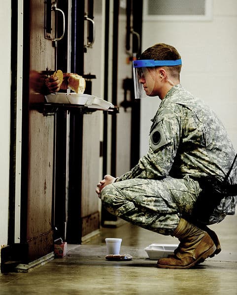 Meal time at Guantanamo Bay. Guards wear masks because sometimes urine or feces will come flying out of the food portal.