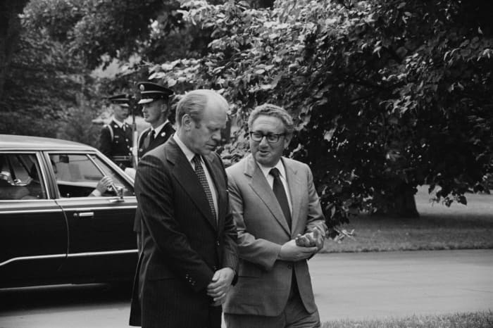 President Gerald Ford and Secretary of State Henry Kissinger, conversing, on the grounds of the White House, Washington, D.C..