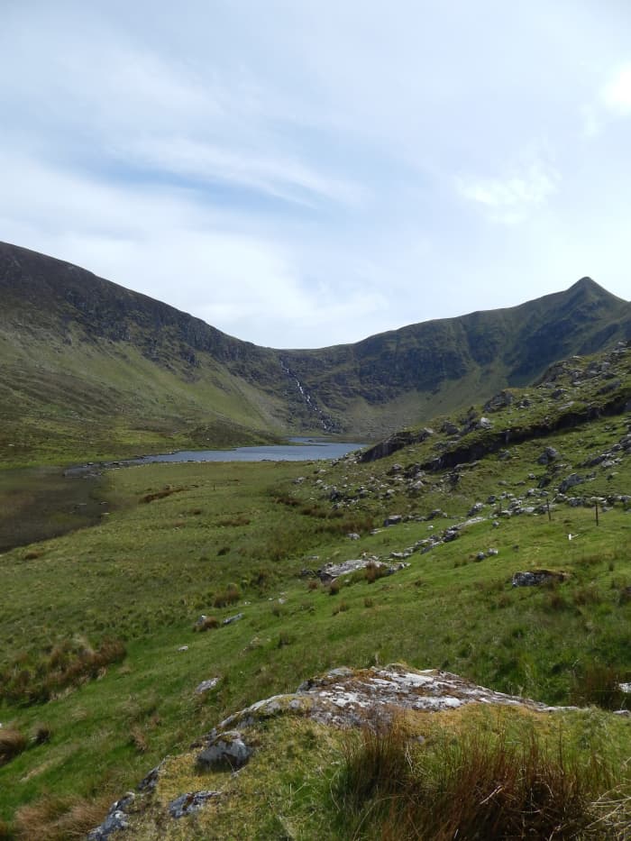 Loch a'Dúin. The ruined fort can be seen on an island in the centre of the lake, with the remains of clocháns (bee hive huts) clustered on the edge of the water.