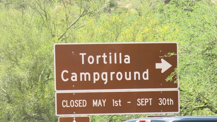 Sign shows Campground by Canyon Lake closed May 1-Sep 30. Winter, not Summer, is the tourist season here.