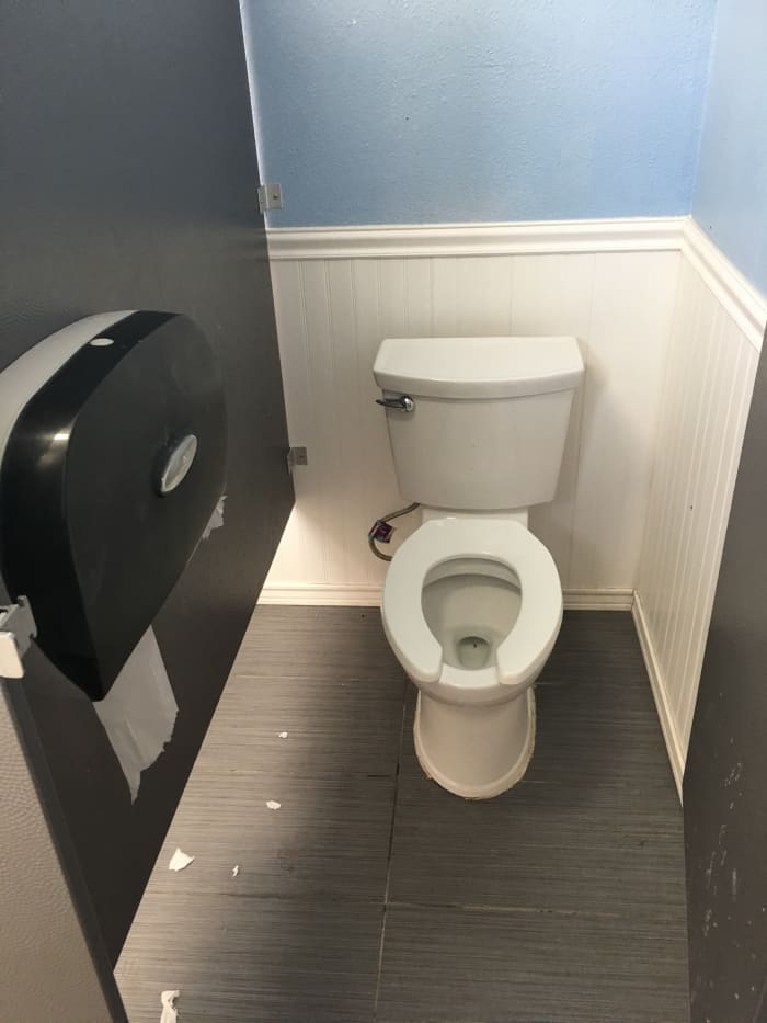 A typical RV campground toilet, clean and functional. Those little pieces of paper have been pulled from a improperly mounted roll of toilet paper.