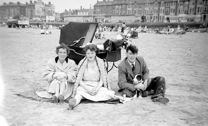 My mother (pictured on the left) as a young woman in the early 1960s, with her brother Ken, his wife Anne and their little puppy on the beach.