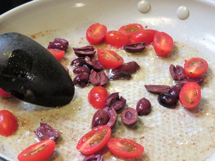 Add the tomatoes and olives to the pan followed by the wine, lemon juice, and final pat of butter. Cook until the liquid reduces by half.