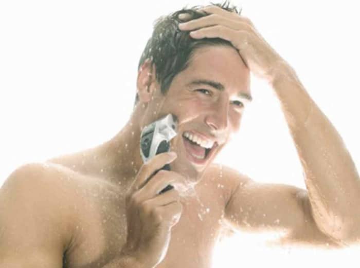 This is a happy man. It due to him shaving first, then showering or has he already showered and now shaving?