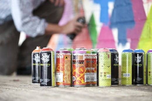 Using spray paint cans to create a mural.