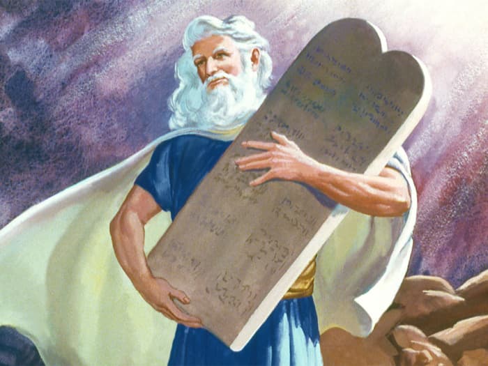 Moses with the Ten Commandments written on stone tablets by the hand of God.