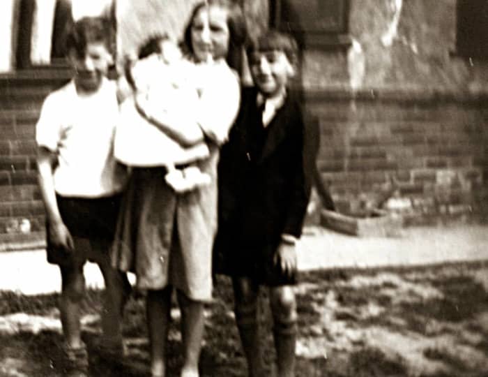 Mum as a child (holding her baby cousin, Shirley Brown) with her little brother Ken on the left and a neighbour's son on the right. They were playing in the street where they grew up in Leeds, Yorkshire.