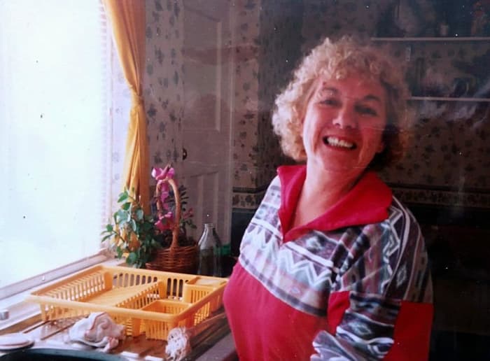 Mum in the late 1990s, washing the dishes while she was dog-sitting for me at my house while I was at work.