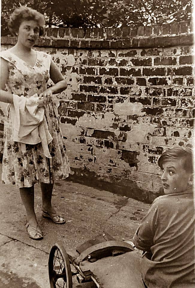 Mum and my brother Eric in the back yard of grandma's guesthouse in the late 1950s. My brother was getting his kart ready to use on the beach.