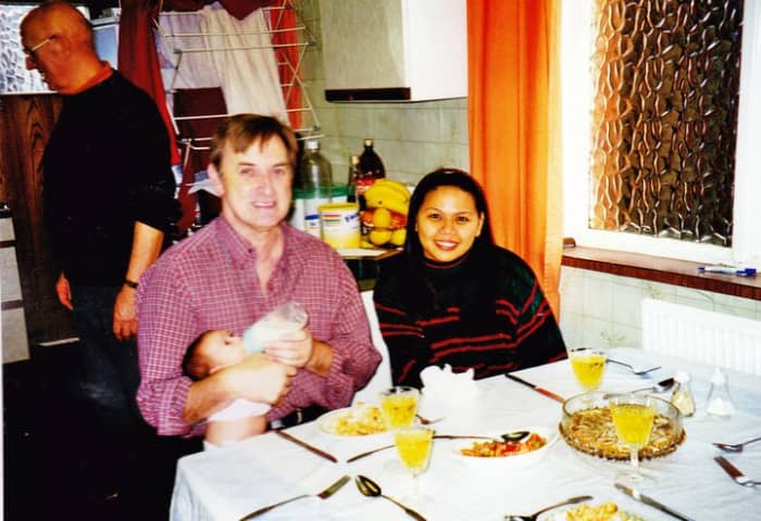 My brother Eric, my sister-in-law Liza and my niece Becky when she was a tiny baby, sitting in the kitchen of the house where we grew up, with our dad in the background.