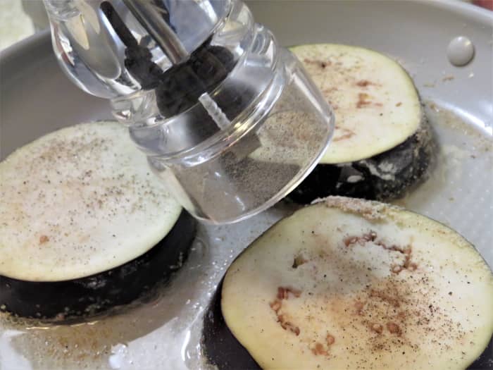 Put the coated side of eggplant into a pan with several tablespoons of the olive oil and season the uncoated side with the salt and pepper.