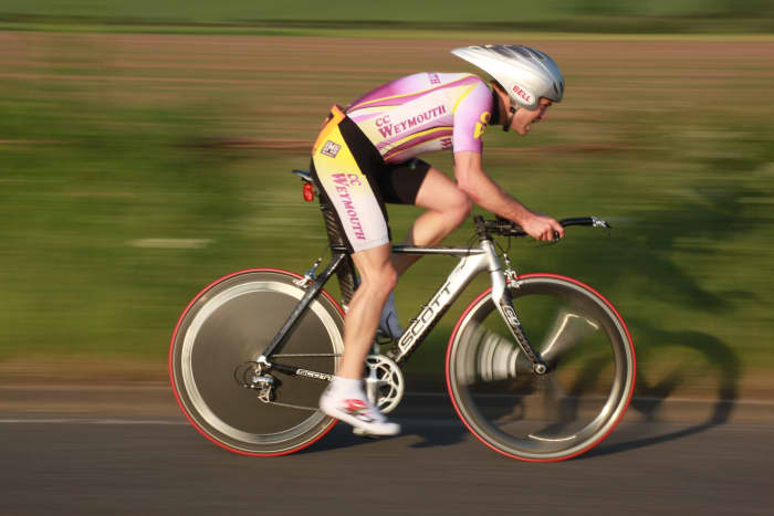 An aerodynamic helmet, time trial bicycle, and aerodynamic wheelset with a rear disc can help you ride a faster time trial. Bike pictured is a Scott Plasma with a front HED tri-spoke carbon wheel and disc wheel to cut through the air.