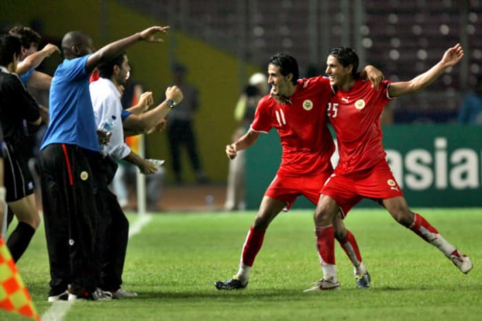 Ismail Abdul-Latif (11) and Faouzi Mubarak Aaish (25) celebrate with personnel after Abdul-Latif scored the winning goal to give Bahrain a shocking 2-1 victory over South Korea
