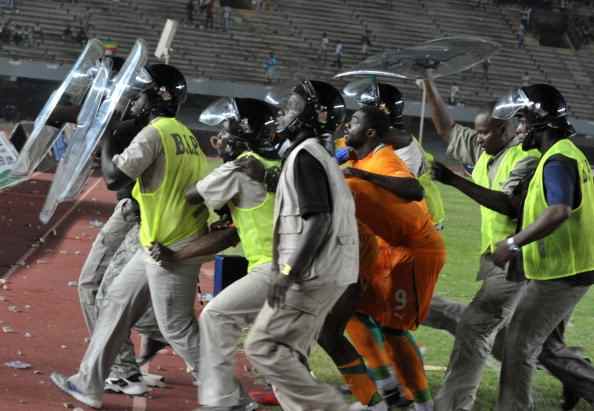Police escort players from Ivory Coast as fans rioted during Senegal's second leg against Ivory Coast in a 2013 AFCON qualifier in Dakar, Senegal.