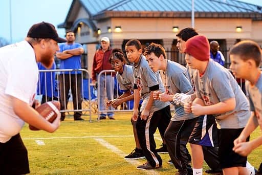 Youth football players at Luke Air Force Base conduct physical fitness drills.