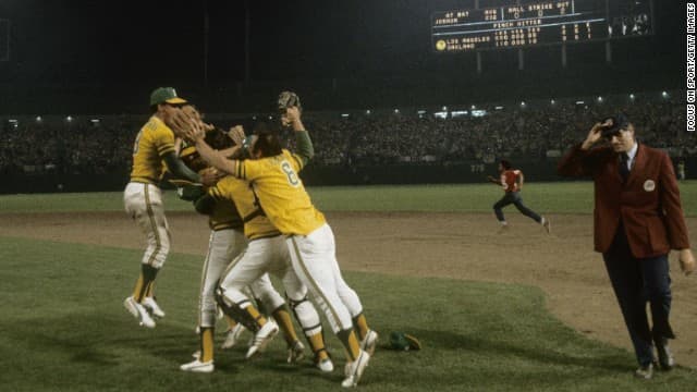 A's celebrate their third straight World Series Championship as umpire Ron Luciano tries to get off the field.
