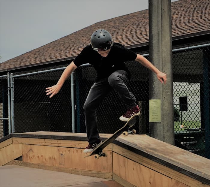 Justin continues to challenge himself on the board, setting an example for young skateboarders at the park.