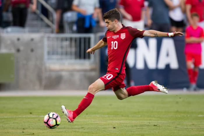 Christian Pulisic taking a hard shot while playing for the U.S. Men's National Soccer Team.