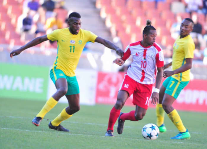 Madagascar's Andriamirado Hasina (#10) battles for possession with South Africa's Matlhari Makaringe (#11) during a 2018 COSAFA Cup quarterfinal in Polokwane, South Africa. Madagascar eliminated the hosts on a penalty shootout.