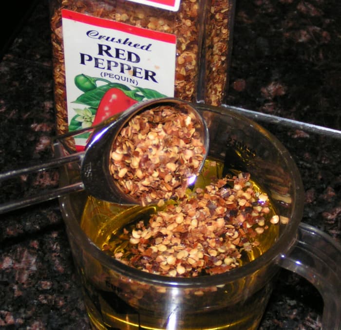 The night before you want to make them, or 24 hours before (depending on how hot you want them to be), pour 1 tablespoon of crushed red chili peppers in olive oil.