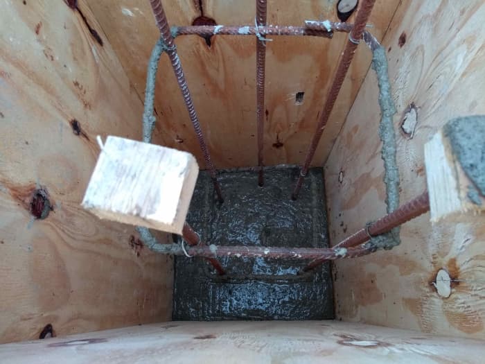 When concrete is poured, tamp it down and into the corners. Then rod it with a length of rebar to remove voids.