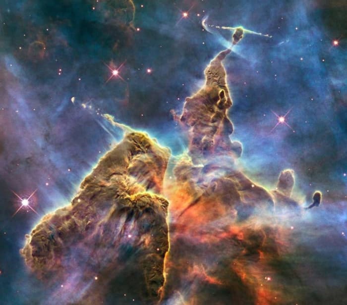 Hubble Space Telescope photo is but a small portion of one of the largest seen star-birth regions in the galaxy, the Carina Nebula. Towers of cool hydrogen laced with dust rise from the wall of the nebula.