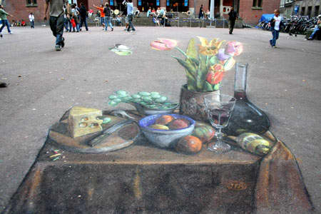 This drawing in Amsterdam is thought to be the first anamorphic still-life ever to be drawn on a pavement. The real-life arrangement was set up in situ.