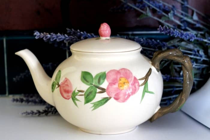 A rosebud knob and a stem handle add to the charm