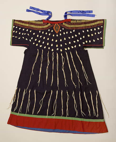 Often found in Idaho, the wing dress came from the tail dress or two hides dress. The T-shaped yoke extends into cape-like sleeves. A printed cotton shirt or skirt was worn under the wing dress.
