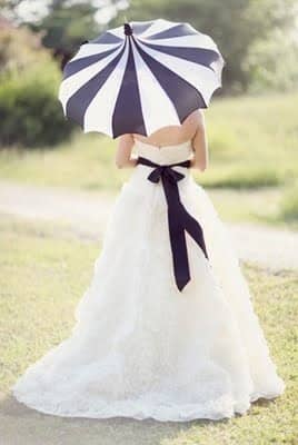 This black and white umbrella is the perfect accessory to match the bride's white gown with a black ribbon.