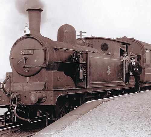 Stockton-on-Tees allocated push-pull fitted 67318 stands at a platform end with station master posing together with the crew on possibly her last working day