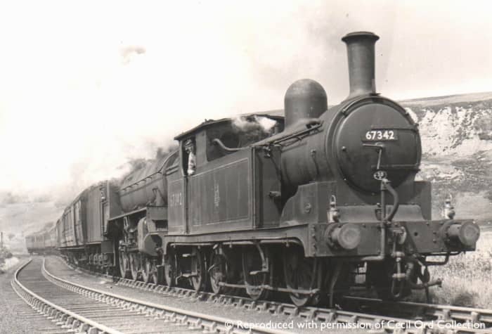 Darlington G5 67342 pilots an unknown Class B1 4-6-0 with a heavy Whitby-bound holiday express (two lamps on the pilot) over Goathland summit - she may have taken a train to Malton and been seconded to this duty to return to her home depot