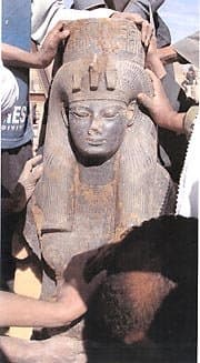 Black granite statue of Queen Tiye, mother of Akhenaton. This statue features a standing Queen Tiye wearing a wig and a cobra-decorated crown.