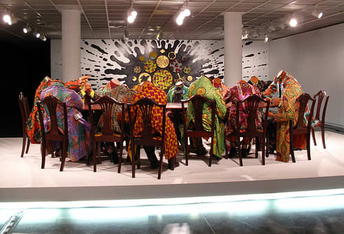 Decapitated African heads, clad in African cloth, bought from Dutch, who took the Batik from Indonesia, and the cloth making technique from Africa, and resold it to Africans