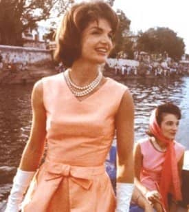 Jackie Kennedy wearing her three strand pearl necklace with her sister Lee in the background