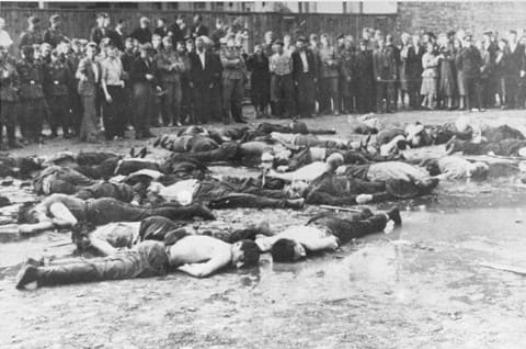 Crowd views the aftermath of a massacre at Lietukis Garage, where pro-German Lithuanian nationalists killed more than 50 Jewish men. The victims were beaten, hosed, and then murdered with iron bars. Kovno, Lithuania, June 27, 1941.
