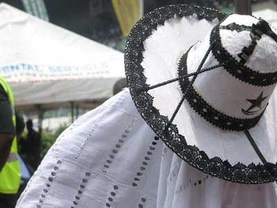 Adimu Orisa Hat - A predominantly white hat with black embroidery works. This style of hat is worn by the most senior Eyo masquerades.