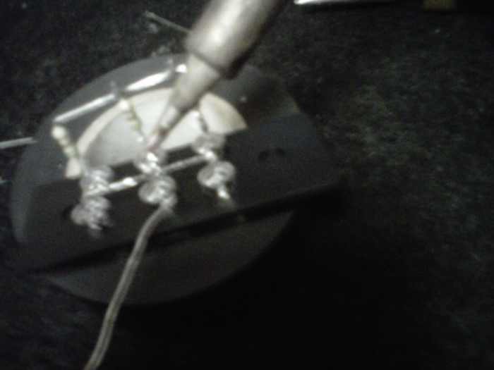 Soldering the lead across the - side. See that the + side (with resistors) is already done.