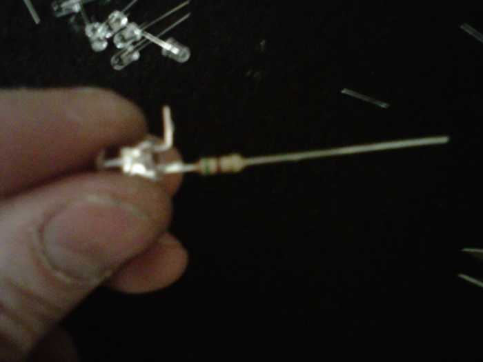 LED with - lead clipped, tinned, and bent 90-ish degrees. The + lead has the resistor soldered to it already.