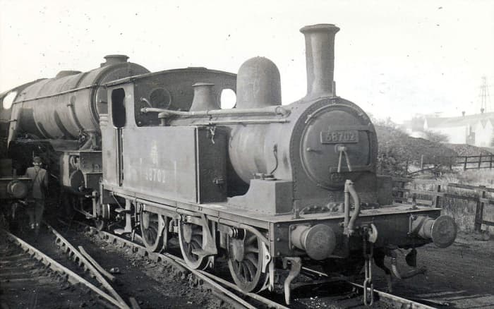 Gateshead (52A) J72 68702 stands in the back roads in front of an unidentified V2 at her home shed. Most of the J72 class were un-fitted, equipped with 3-link couplings for yard work and trip-working between yards.