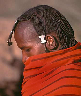 After circumcision, the young warriors grow their hair again and spend a great deal of time styling it. The plaited hair is dressed with animal fat and ocher, and parted across the top of the head at ear level.