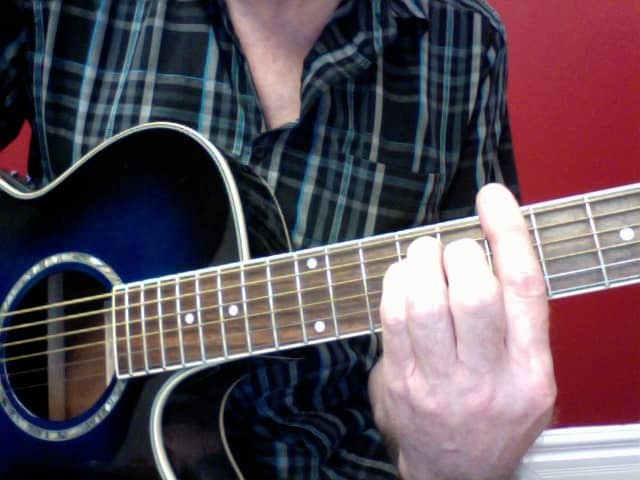 Front view of the correct hand position. There is a slight curve on the barre finger towards the nut. This will allow your elbow to be pulled in towards your body
