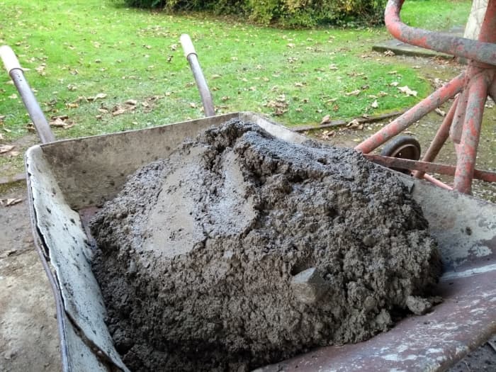 Concrete should be stiff so it doesn't squeeze out from underneath stones and they don't sink into it.