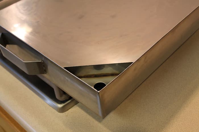 Pan has a water reservoir to hold near 2 gals of water. The water maintains even heat without scorching.