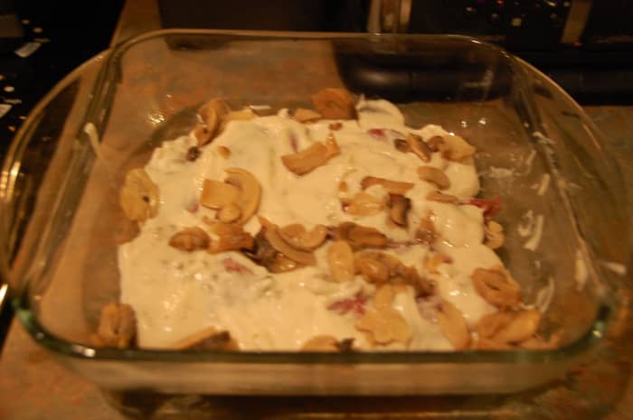 Loins covered with cream of mushroom soup and extra mushrooms, ready to go in the oven